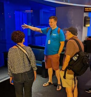 skupina lidí stojících kolem muže ukazujícího