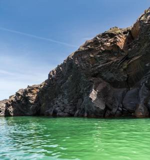 en klippformation i vattnet bredvid ett berg