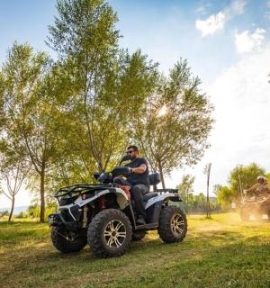 两个人骑着四轮摩托车在土路上行驶