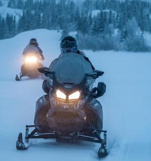 两个人在雪地里骑着雪地摩托