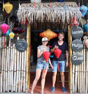 两名妇女站在商店前,手里提着灯笼