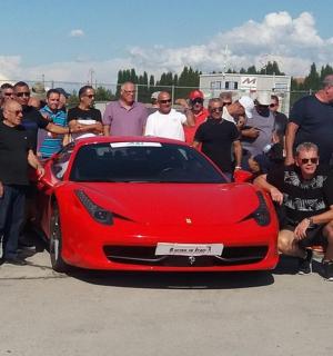 một nhóm người đứng xung quanh một chiếc xe màu đỏ