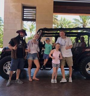 a group of people standing in front of a jeep