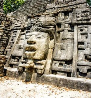 a stone statue of a face on the side of a building