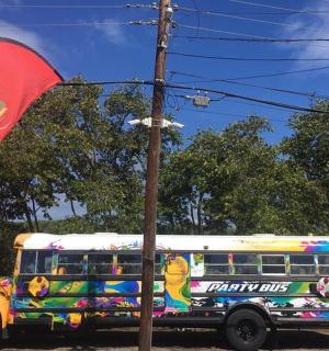 kolorowy autobus szkolny zaparkowany obok flagi