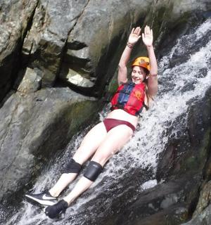 Žena leží na skále u vodopádu