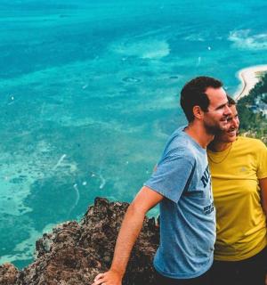 a man and a woman sitting on top of a mountain