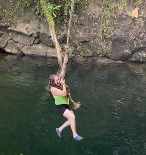 a woman hanging from a rope in a river