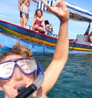 a woman in the water with a microphone in front of a boat