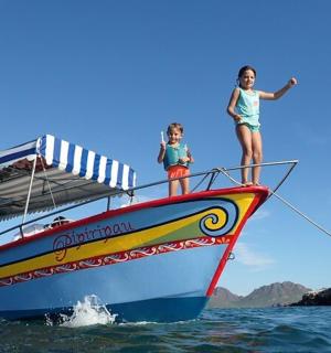 dua gadis berdiri di depan perahu di air