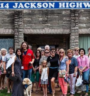 skupina lidí pózujících pro fotografii před budovou