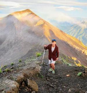 čovjek stoji na vrhu planine sa zmajem