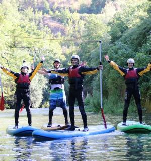 一群人站在河上的桨板上