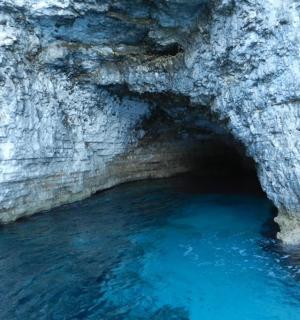 jeskyně s modrou vodou v kamenné zdi