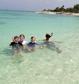 tři lidé ležící ve vodě v oceánu