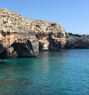 a large body of water next to a rocky cliff