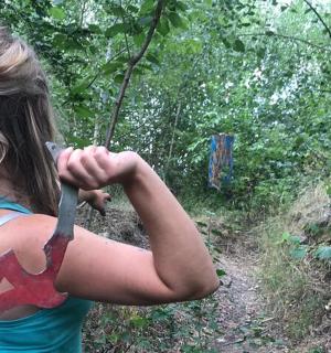 a woman holding a knife in the woods