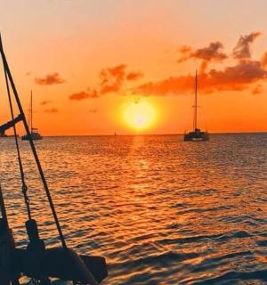 a group of people on a boat in the water at sunset