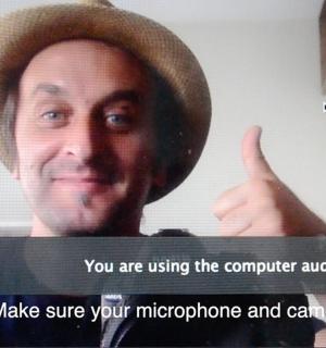 a man in a hat giving a thumbs up