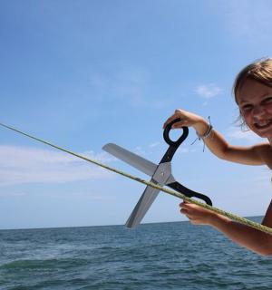 mladá dívka držící se za lano s nůžkami