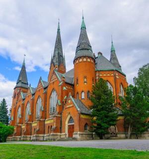 绿色田野上一座带有塔楼的大型橙色建筑