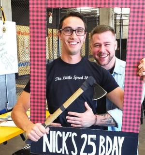 a man holding a sign with a baseball bat