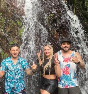 三个人站在瀑布前