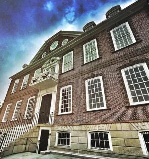 Velká cihlová budova s bílými okny na ulici