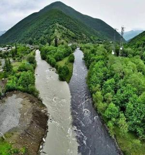 an aerial view of a river next to a road