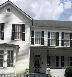 一栋带黑色百叶窗的白色房子