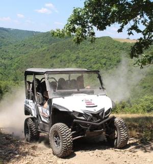 bílá čtyřkolka jedoucí po nezpevněné cestě