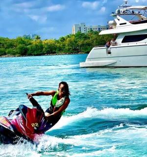 žena na vodním skútru ve vodě vedle jachty
