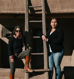 dvě ženy stojí vedle žebříku