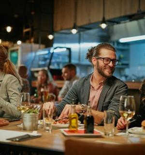 a group of people sitting around a table in a restaurant