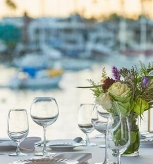 stůl s sklenicemi na víno a vázou s květinami