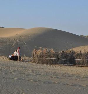 两个人坐在沙漠里的沙子上