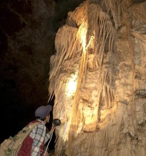 一个人站在洞穴里看着岩层