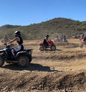 一群人骑着四轮摩托车在泥地上行驶