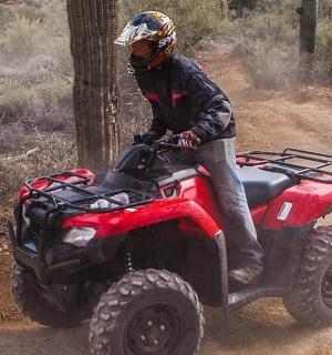 a man riding a four wheeler on a trail