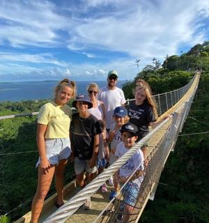 a group of people standing on a walkway on a suspension bridge