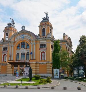 un gran edifici groc amb estàtues a sobre