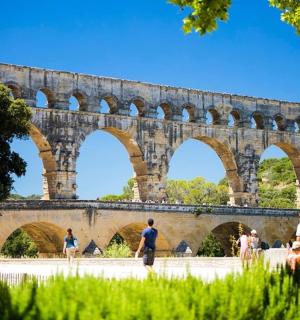 a large stone bridge with people walking under it