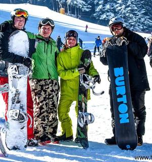 一群人站在雪地里，手里拿着滑雪板