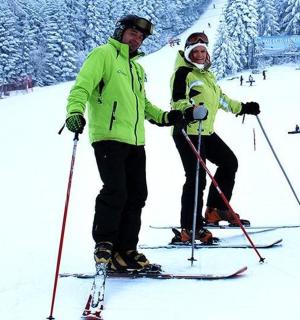 两个人站在雪地里的滑雪板上