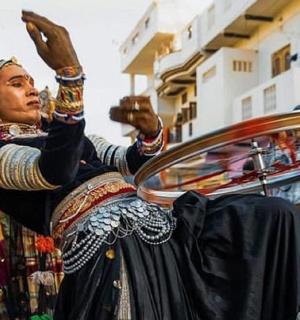 一位身穿连衣裙、举着手的女士