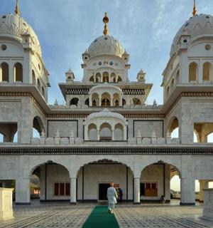 一名男子走在一栋大楼前