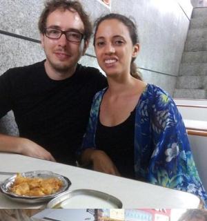 一男一女坐在桌边,桌上摆着一盘食物