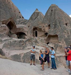 a group of people standing in front of a rock formation