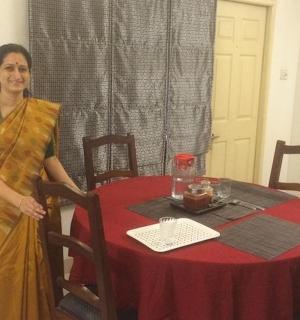 a woman standing next to a table with a red table cloth