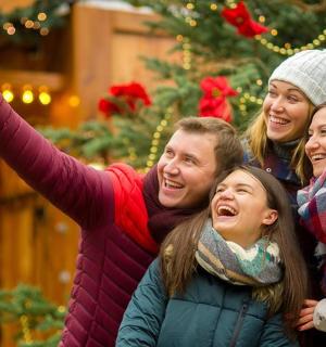 a group of people posing for a picture in front of a christmas tree